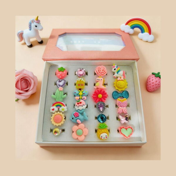 set-inele-distractive-pentru-copii-continut Set inele distractive pentru copii, cutie roz deschisă cu 24 de inele așezate pe patru coloane, cu decoruri de flori, fructe