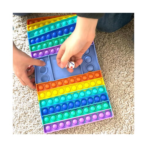 set-jucarie-interactiva-super-fidget-utilizare Set Jucărie interactivă, tablă Pop It dreptunghiulară în culori curcubeu, pe covor