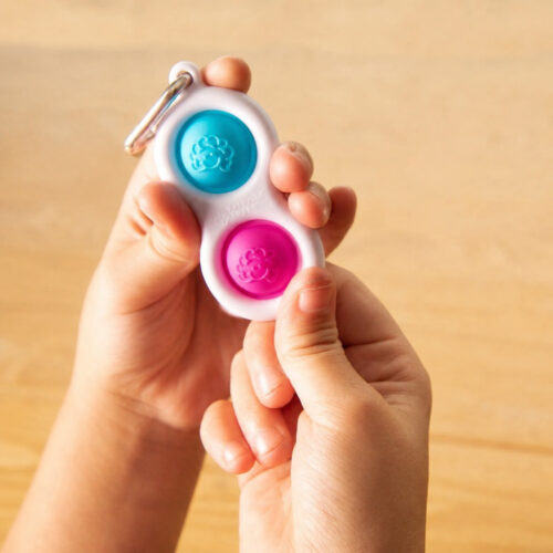 Set Pop It Caracatiță, mână care ține o jucărie Simple Dimple albă în formă de opt