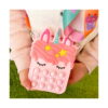 Set Pop It unicorn cu geantă și accesorii, prim-plan cu geanta unicorn roz ținută în mâini: coamă roz, trei stele galbene