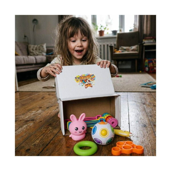 Set senzorial iepuraș, fetiță care deschide o cutie Spoki; în față iepuraș roz squishy, minge puzzle curcubeu
