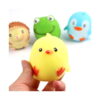 Set squishies animale, puișorul galben ținut între degete în prim-plan, cu ariciul, broscuța și pinguinul neclari în fundal