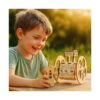set-stem-3-in-1-exploratorul-utilizare Set STEM 3 în 1 Exploratorul, băiat la o masă afară, cu telecomanda în mână, lângă robotul din lemn cu două roți mari