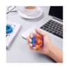 Snapperz multicolor din cauciuc, mână care strânge un Snapperz multicolor la un birou, lângă un laptop