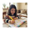 squishy-pix-utilizare Pix squishy, fetiță la masă care scrie într-un caiet cu un pix squishy galben
